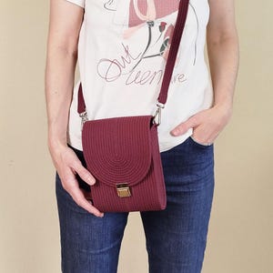 Crossbody – eine Handtasche über der Schulter. Eine kleine burgunderfarbene Handtasche. Kordeltasche aus Baumwolle.