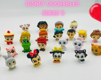 Puede incluir: Una colección de 20 figuras Disney Doorables Serie 5. Las figuras son pequeñas, coloridas y presentan personajes de películas populares de Disney. Los personajes incluyen Mickey Mouse, Minnie Mouse, Ariel, Belle y muchos más.