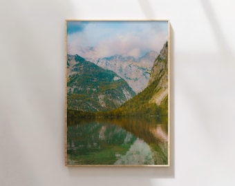 以下が含まれることがあります： 山と湖の風景写真。湖面には周りの山々が映り込んでいる。山は緑の木々で覆われ、湖面は穏やかな青色をしている。