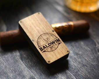 Puede incluir: Una caja de madera con un borde negro y un logotipo grabado con láser que dice "FINE CIGAR SELECTION BALDWIN EST. 1927 SINCE 1927".