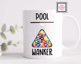 May include: White ceramic mug with a black and white graphic. The mug features the word "POOL" above a pool cue and a triangle of billiard balls. Below the balls is the word "WANKER" in bold black letters. The Trendy Edit logo is in the upper right corner.
