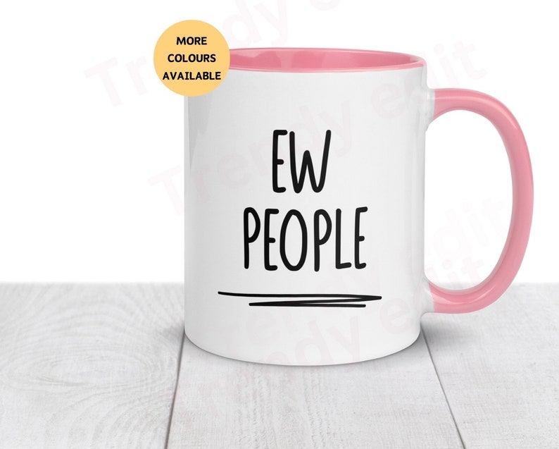 May include: White ceramic mug with a pink rim and handle. The mug has black text that reads "EW PEOPLE" with a black line underneath.