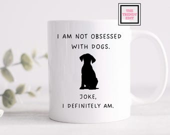 May include: White ceramic mug with a black silhouette of a dog and the text "I am not obsessed with dogs. Joke, I definitely am."