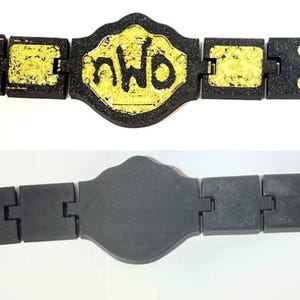 May include: A black and yellow championship belt featuring the letters "nWo" on the central plate. The belt is constructed from linked rectangular sections. A grey version of the belt is shown below.
