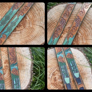 May include: Two leather straps with intricate carvings of swirling patterns and green and blue accents. The straps are laid out on a wooden surface.