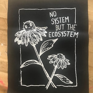 May include: Black iron-on patch with white text and a graphic of two stylized flowers. The text reads "No system but the ecosystem."