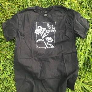 May include: Black t-shirt with a white graphic of a flower and the text "NO SYSTEM BUT THE ECOSYSTEM".