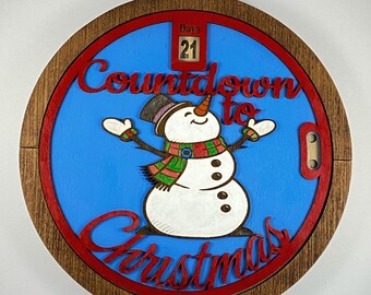 Percha de pared intercambiable de madera pintada a mano con forma de muñeco de nieve navideño.