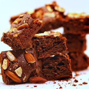 Peut inclure: Une pile de brownies au chocolat garnis d'amandes. Les brownies sont d'une couleur brun fonc&eacute; riche et ont une texture l&eacute;g&egrave;rement croustillante. Les amandes sont de couleur brun clair et ajoutent une texture croquante aux brownies.