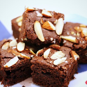 Peut inclure: Une assiette de brownies au chocolat garnis d'amandes effil&eacute;es. Les brownies sont d'une couleur brun fonc&eacute; riche et les amandes sont d'un blanc cr&eacute;meux clair.