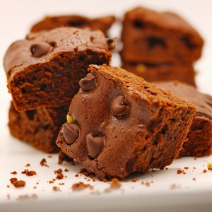 Peut inclure: Gros plan sur une pile de brownies au chocolat avec des p&eacute;pites de chocolat. Les brownies sont d'une couleur brun fonc&eacute; riche et ont une surface l&eacute;g&egrave;rement brillante. Les p&eacute;pites de chocolat sont dispers&eacute;es dans les brownies et sont d'une couleur brun plus clair.