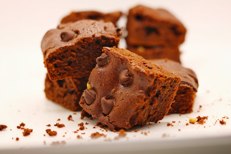 Peut inclure: Gros plan sur une pile de brownies au chocolat avec des p&eacute;pites de chocolat. Les brownies sont d'une couleur brun fonc&eacute; riche et ont une surface l&eacute;g&egrave;rement brillante. Les p&eacute;pites de chocolat sont dispers&eacute;es dans les brownies et sont d'une couleur brun plus clair.