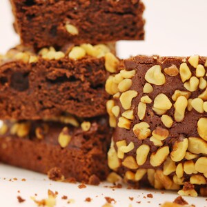 Peut inclure: Une pile de brownies au chocolat garnis de noix hach&eacute;es. Les brownies sont d'une couleur brun fonc&eacute; riche et ont une texture l&eacute;g&egrave;rement friable.