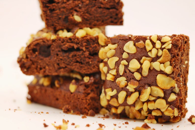 Peut inclure: Une pile de brownies au chocolat garnis de noix hach&eacute;es. Les brownies sont d'une couleur brun fonc&eacute; riche et ont une texture l&eacute;g&egrave;rement friable.