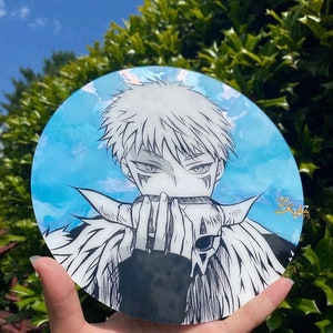 May include: A round, blue and white watercolor painting of a character with white hair and a skull mask. The character is wearing a black jacket and has a white fur collar.