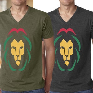 May include: Two V-neck t-shirts with a graphic of a lion's head with a red, yellow, and green mane. The lion's head is centered on the shirt. The shirt on the left is olive green and the shirt on the right is dark gray.