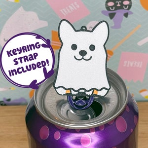 May include: A purple Bubly sparkling water can with a blackberry flavour. The can is 355 ml. A white ghost-shaped keychain with a black face and ears is on top of the can.