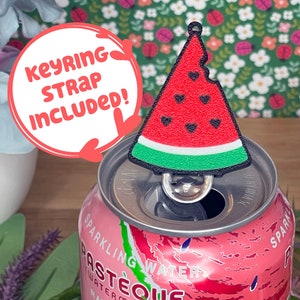 May include: A watermelon-shaped keyring charm with a bite taken out of it, featuring a red body with black heart seeds and a green rind. The charm is attached to a soda can. The text "KEYRING STRAP INCLUDED!" is in a white circle.