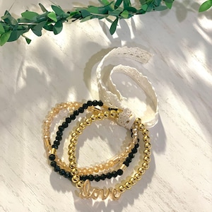 Conjunto de pulseras de cuentas apiladas con dijes de amor dorados