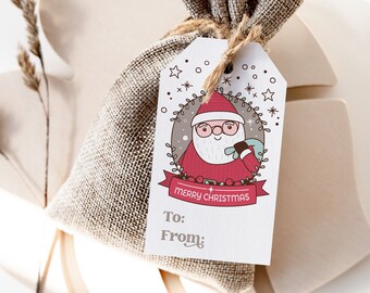 May include: A white gift tag with a cartoon illustration of Santa Claus holding a gift. The tag says "Merry Christmas" and has spaces for "To:" and "From:". The tag is attached to a brown burlap gift bag.