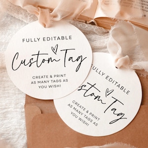 May include: Two circular white paper tags with black text that reads FULLY EDITABLE Custom Tag CREATE & PRINT AS MANY TAGS AS YOU WISH! Each tag features a small heart icon and is tied with a light peach-coloured frayed silk ribbon.