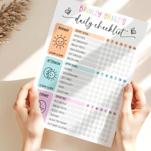 以下が含まれることがあります： 「Brinley Grace's Daily Checklist」と書かれたデイリーチェックリストを人が持っています。チェックリストには、朝、午後、夜のルーティンがあり、各タスクにチェックボックスがあります。デザインはパステルカラーとイラストです。