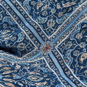 May include: A woven fabric featuring a dense, intricate pattern in shades of deep navy blue, light blue, and cream. The design consists of repeating floral and vine motifs arranged in geometric sections with defined borders and textured threads.