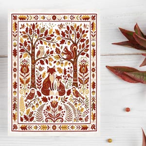 Peut inclure: Une impression rectangulaire présentant une scène de forêt automnale symétrique avec deux renards, un écureuil, des hiboux et des oiseaux entourés de feuilles de chêne, de glands et de motifs floraux dans des tons rouge, orange, brun et crème.