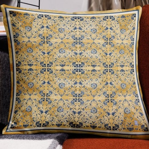 May include: A yellow and blue patterned throw pillow with a white border. The pattern features a repeating floral design.