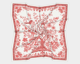 May include: A white silk scarf with a red floral pattern and birds. The design features a stylized tree with branches and leaves, and two birds perched on the branches. The scarf has a red border with a repeating pattern.