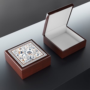 May include: Two wooden boxes with a floral design on the top of one. The box on the left is closed and the box on the right is open.