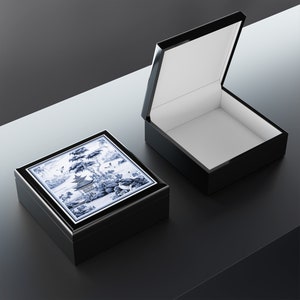 May include: Two black wooden boxes, one open and one closed. The closed box has a blue and white porcelain top with a traditional Chinese design.