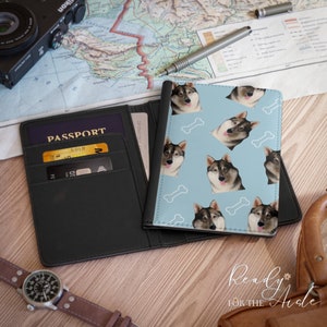May include: A black passport holder with a blue passport cover featuring a repeating pattern of a dog's face and white bone shapes. The text "Ready for the Aisle" is visible in the bottom right corner of the image.