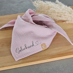 Könnte beinhalten: Ein pinkfarbenes Bandana mit dem Text "Seelenhund" und einem gestickten Herzen. Das Bandana hat einen braunen Lederfleck mit einem Pfotenabdruck.
