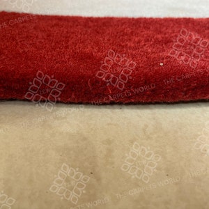 May include: Close-up of a red, white, and blue striped rug with the text "THE CARPETS WORLD" repeated on the rug.