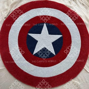 May include: A red, white, and blue round rug with a white star on a blue background. The rug is shaped like Captain America's shield.