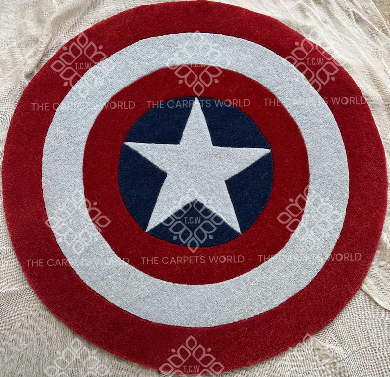 May include: A red, white, and blue round rug with a white star on a blue background. The rug is shaped like Captain America's shield.
