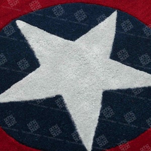 May include: A white star on a blue and red circular rug. The star is in the center of the rug and is surrounded by a blue circle. The blue circle is surrounded by a red circle.