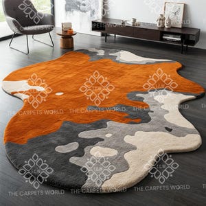 May include: Abstract area rug with a brown, grey, and white colour scheme. The rug has an irregular, organic shape.