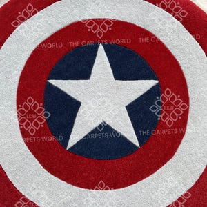 May include: A red, white, and blue circular rug with a white star in the center. The rug has the text "THE CARPETS WORLD" around the edge.