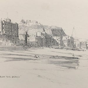 Può includere: Uno schizzo a matita in bianco e nero su carta che raffigura una scena di una città costiera con edifici situati lungo una riva. L'opera presenta il testo "FROM THE BEACH" nell'angolo in basso a sinistra e le iniziali "H.G.M." vicino.