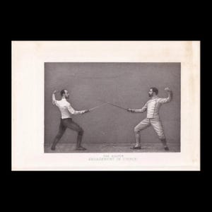 May include: A black and white vintage photograph showing two fencers in a duel. The left fencer wears a white jacket and dark trousers, while the right fencer wears a white jacket and trousers. Text below reads: THE SALUTE ENGAGEMENT IN TIERCE.