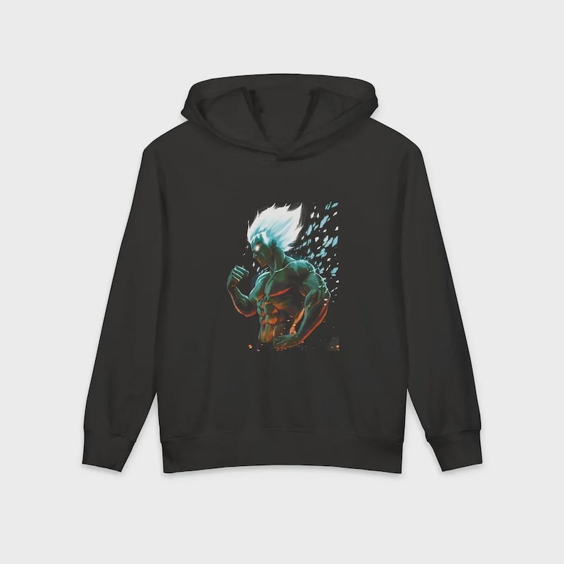 Op de afbeelding: Zwarte hoodie met een gestileerde illustratie van een gespierde figuur met wit haar en blauwe gloeiende accenten. Het grafische ontwerp toont een krachtig personage in een dynamische pose tegen een donkere achtergrond.