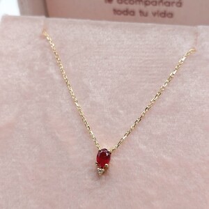 Delicata collana in oro giallo 18 carati con rubino e diamanti decorativi.