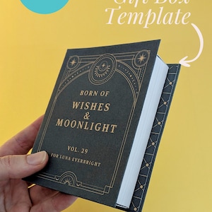 May include: A dark green gift box template with gold accents, featuring the text "BORN OF WISHES & MOONLIGHT" and "VOL. 29 FOR LUNA EVERBRIGHT." The box is held against a yellow background, with the word "Canva" and "Gift Box Template" visible.