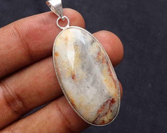 May include: A silver pendant with a white, brown, and orange agate stone. The stone is oval shaped and has a smooth, polished finish.