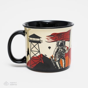 Może przedstawiać: Czarno-biały kubek z beżowym tłem. Kubek przedstawia kreskówkowego astronautę trzymającego flagę z symbolem atomowym. Astronauta stoi na górze z wieżą obserwacyjną w tle.