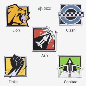 May include: Set of 6 enamel pins featuring Rainbow Six Siege operators: Lion, Clash, Ash, Finka, Capit&atilde;o. Each pin is square shaped with a white border and features the operator's symbol in colour.