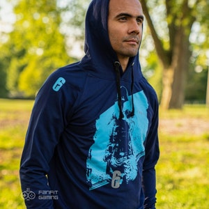 May include: A navy blue hooded sweatshirt with a blue and white graphic print of a person wearing a tactical helmet and holding a gun. The text "Frost" is visible on the graphic. The number "6" is also visible on the graphic.