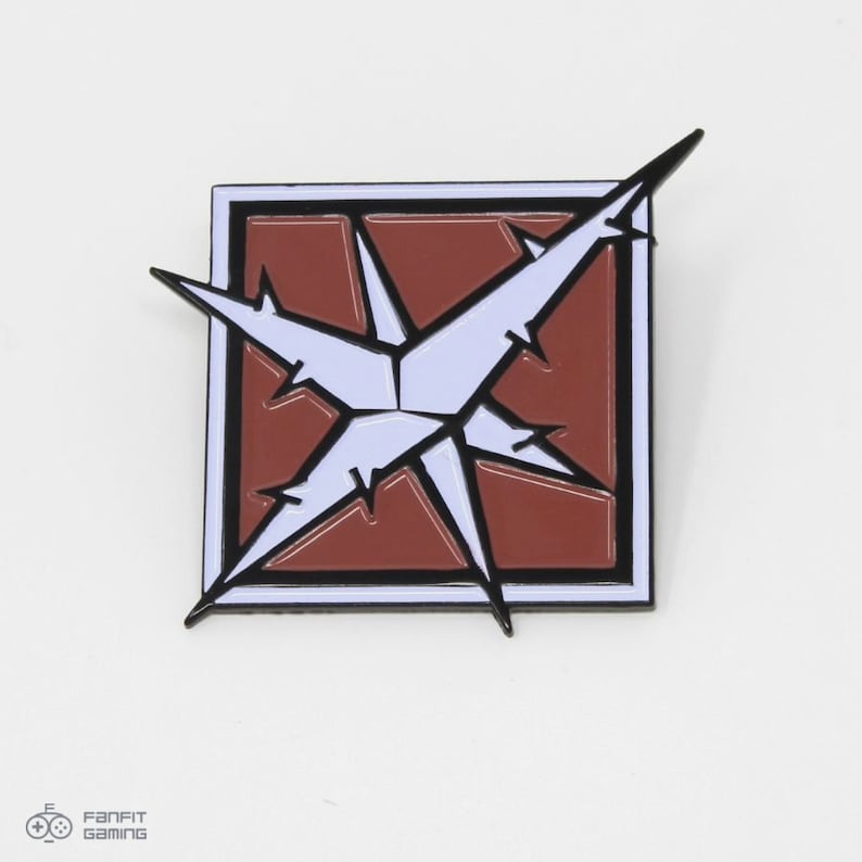 May include: A white and red enamel pin with a starburst design. The starburst is white with black outlines and is set against a red background. The pin is surrounded by a black border.